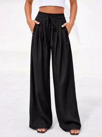 Black wide-leg pants worn by a person on a white background