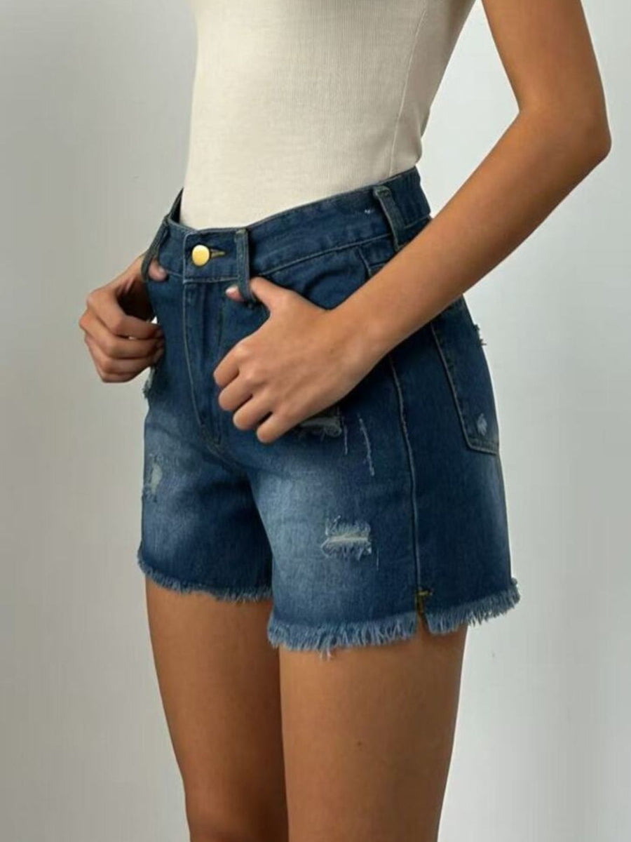 Person wearing blue denim shorts on a plain background