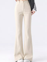 A model is wearing a pair of high-waisted, light beige flare pants with a gray blazer and white sneakers, shown from the waist down against a plain white studio background.