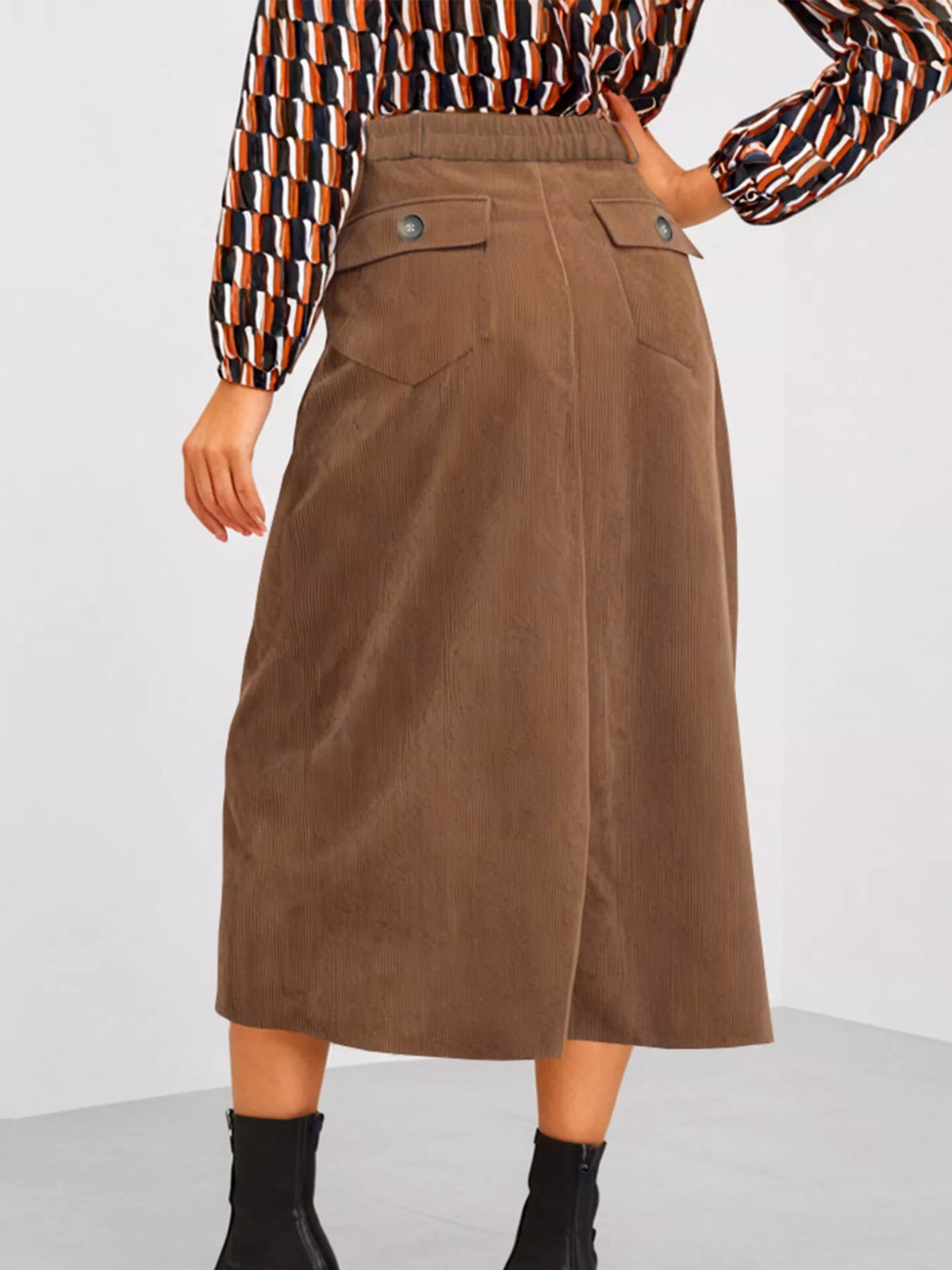 Brown suede skirt worn by a person on a white background