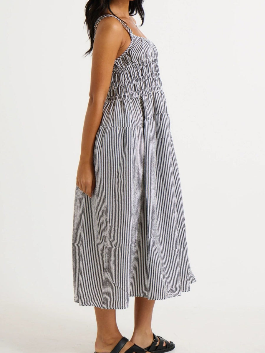 Woman wearing a black and white striped dress on a white background