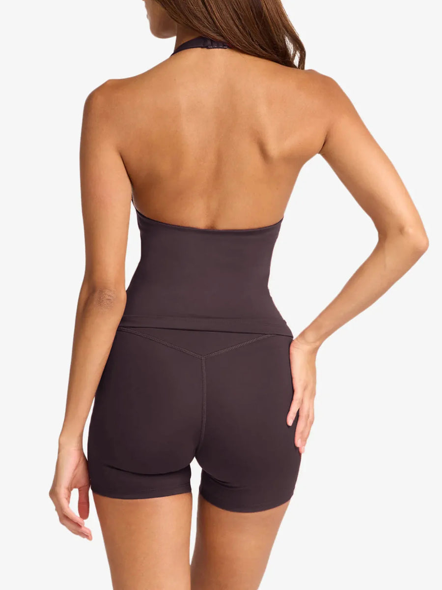 Woman wearing a dark brown halter top and shorts on a white background