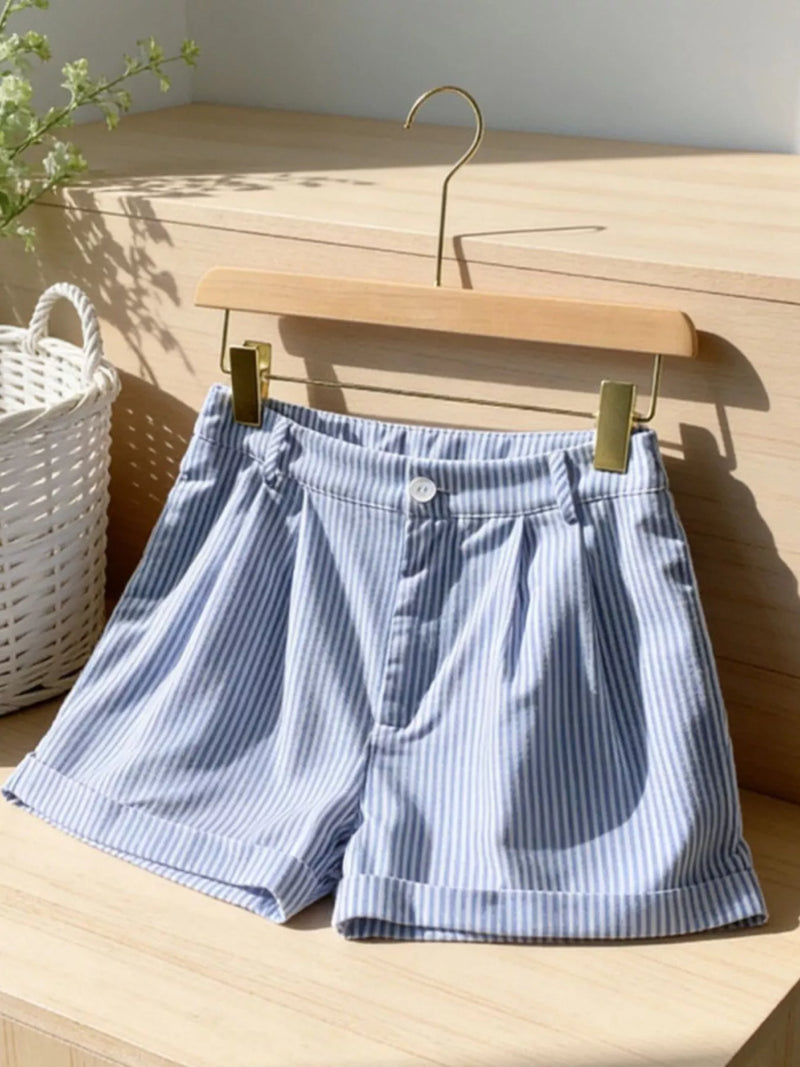Blue and white striped shorts on a wooden hanger against a wooden background