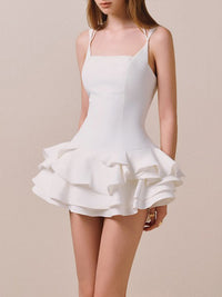 White dress with ruffled skirt on a beige background