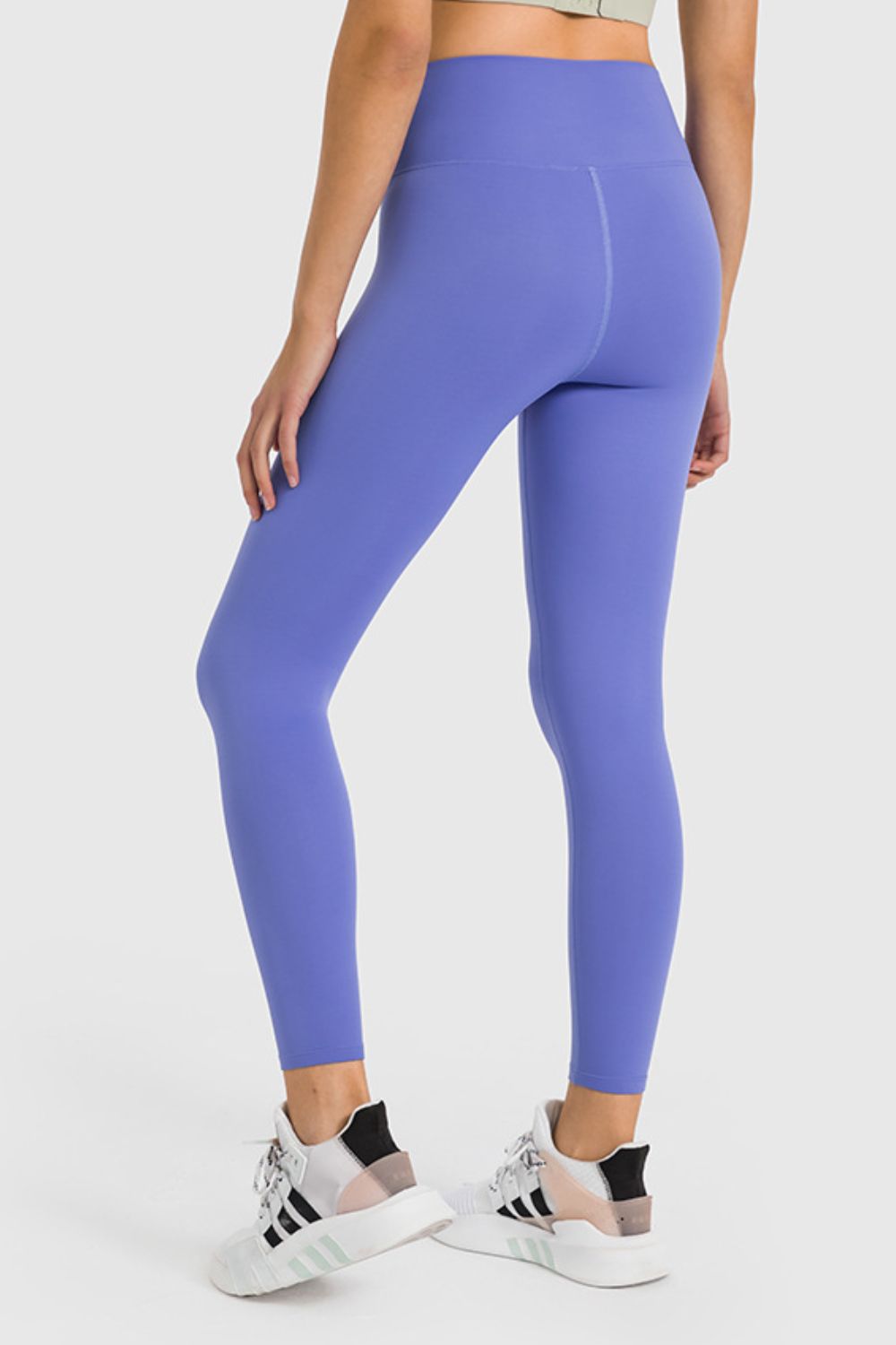 Person wearing purple leggings with a white background