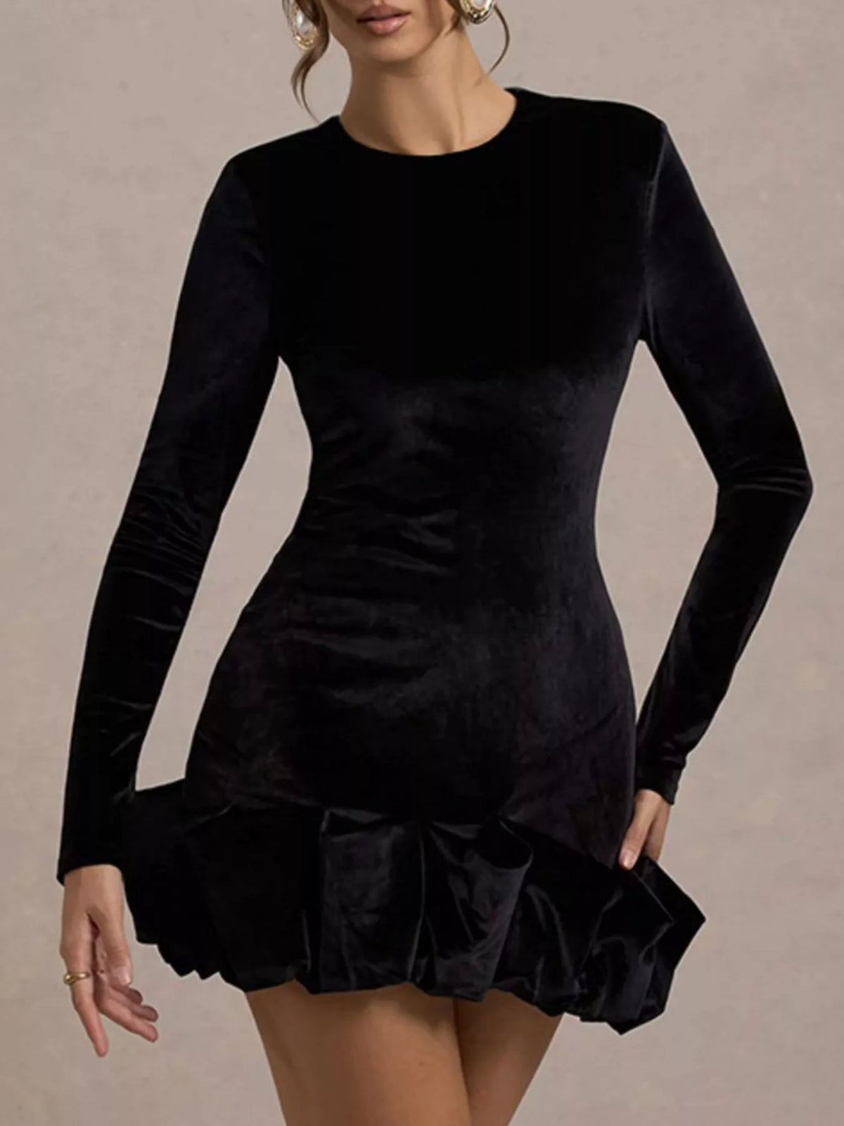 Black velvet dress with long sleeves on a neutral background