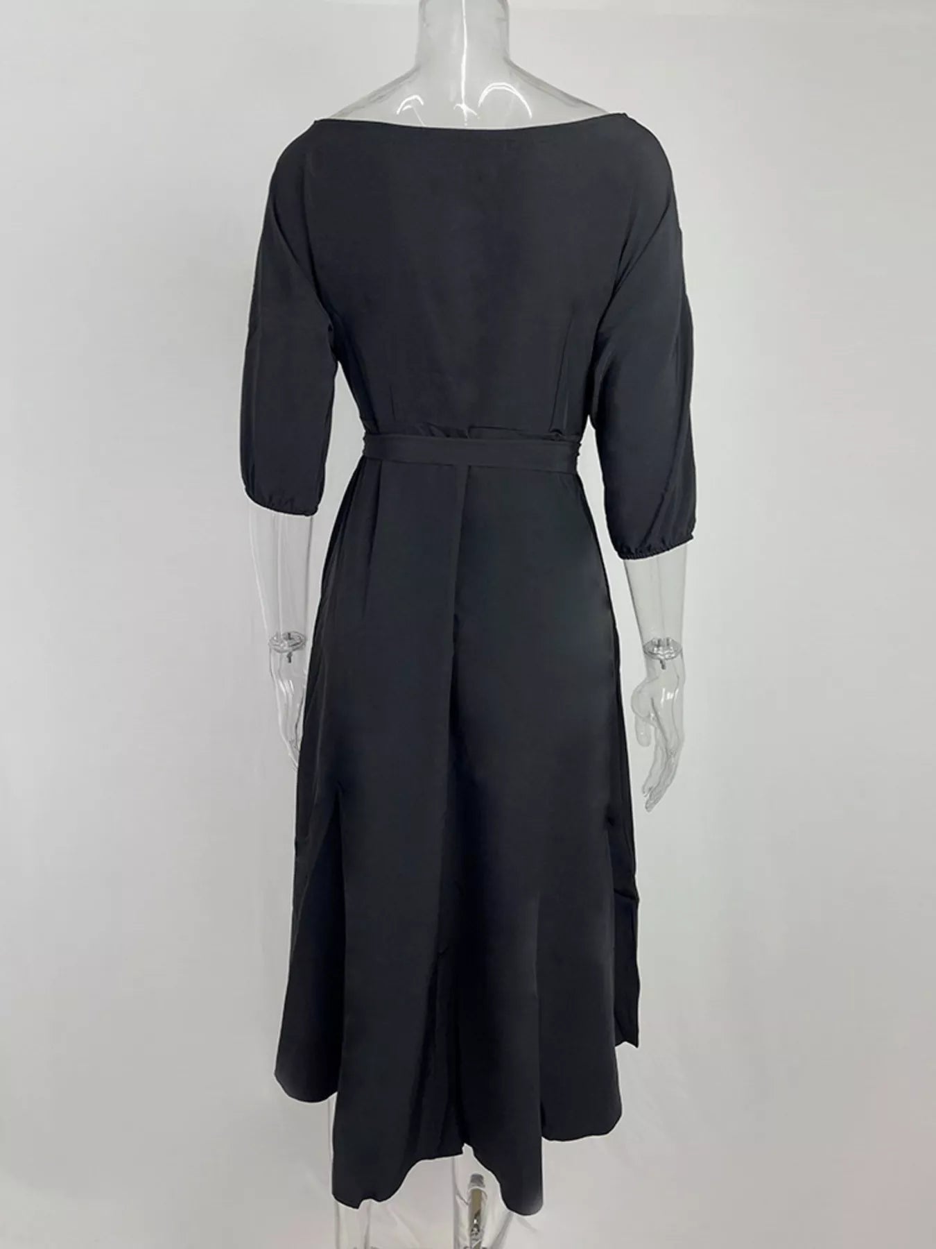 Black dress on a mannequin against a white background