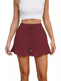 Maroon shorts worn by a person on a white background