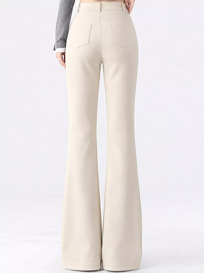 A person shown from the back wearing high-waisted, wide-leg cream pants with a gray long-sleeve top, photographed against a clean white studio background.