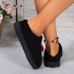Black slippers worn by a person with a blurred background