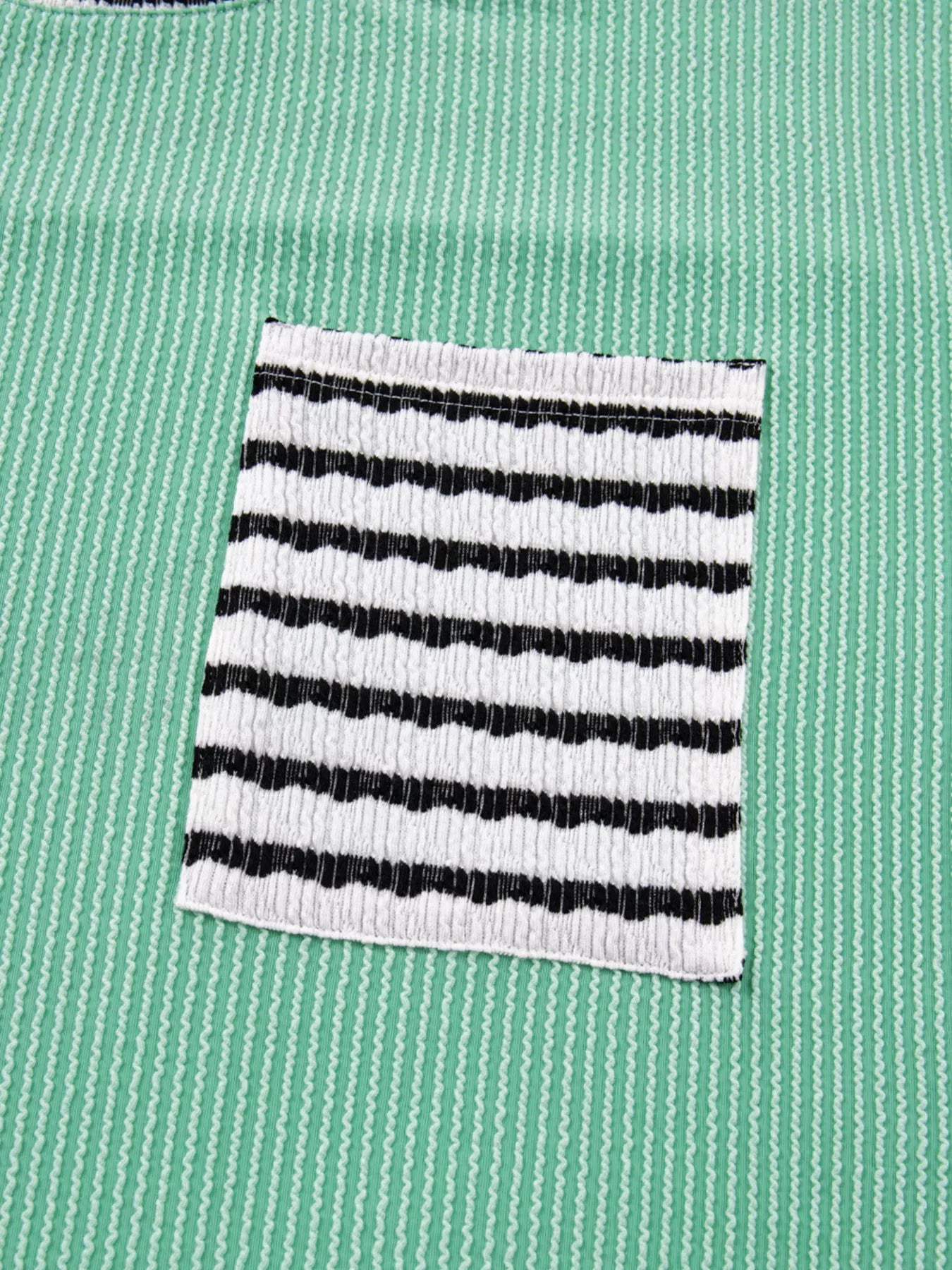 Black and white striped pocket on a green shirt