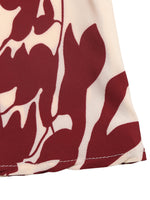 Close-up of a fabric with red floral pattern on a white background