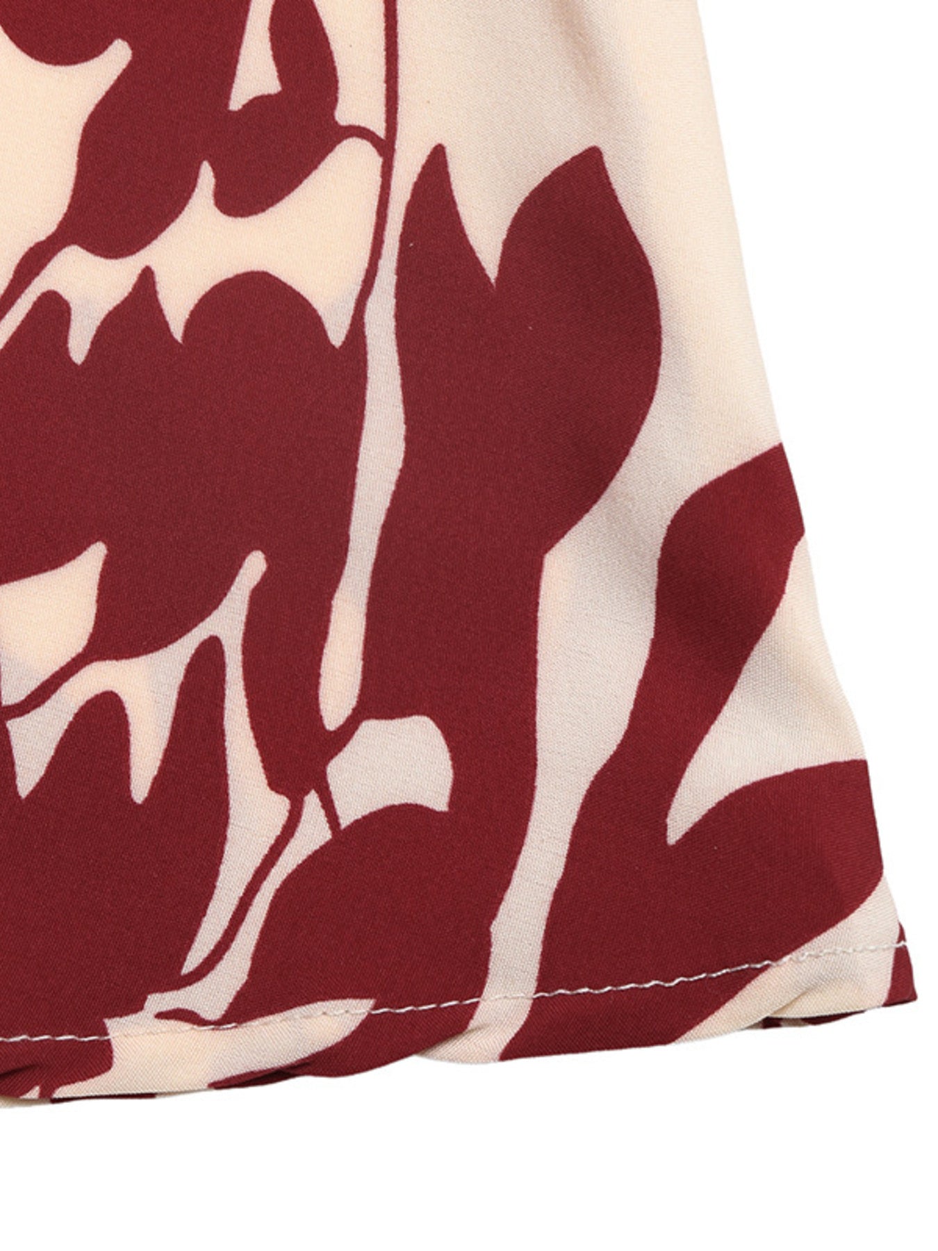 Close-up of a fabric with red floral pattern on a white background