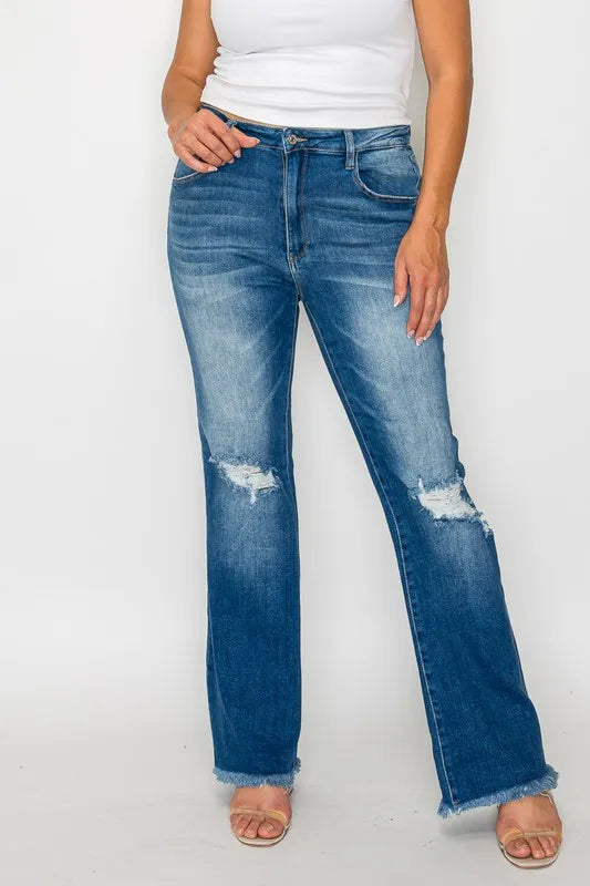 Person wearing blue jeans with slight distressing on a white background