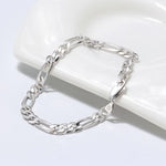 Silver chain bracelet on a white ceramic dish