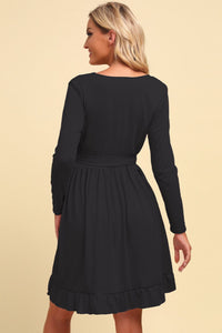Black dress worn by a model on a beige background