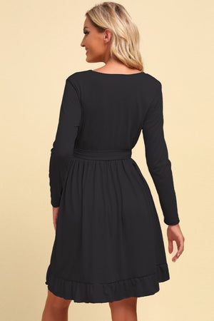 Black dress worn by a model on a beige background