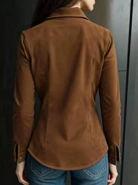 Person wearing a brown jacket against a dark background