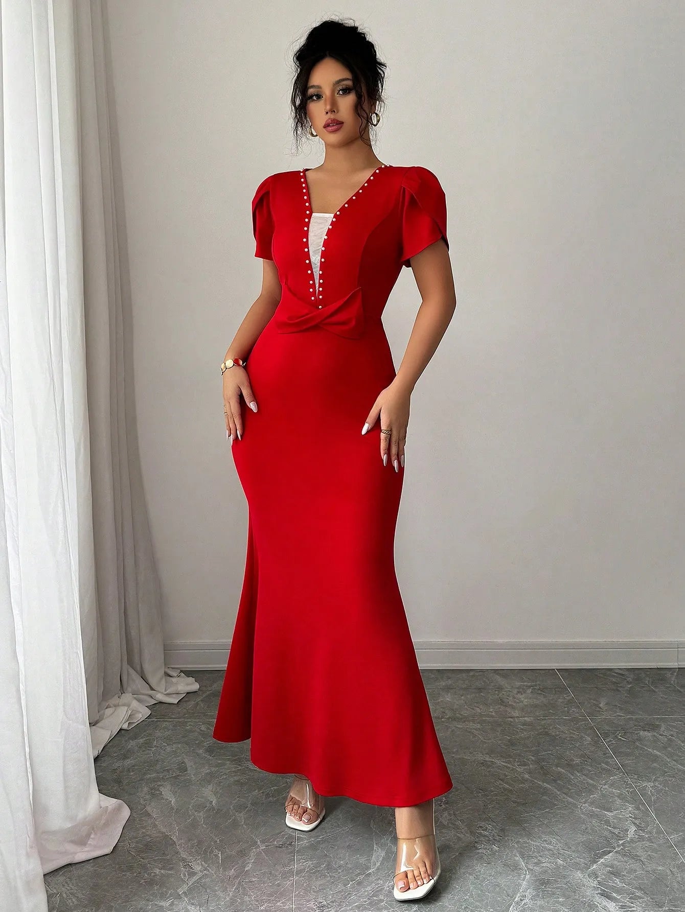 Woman wearing a red evening gown with a white background
