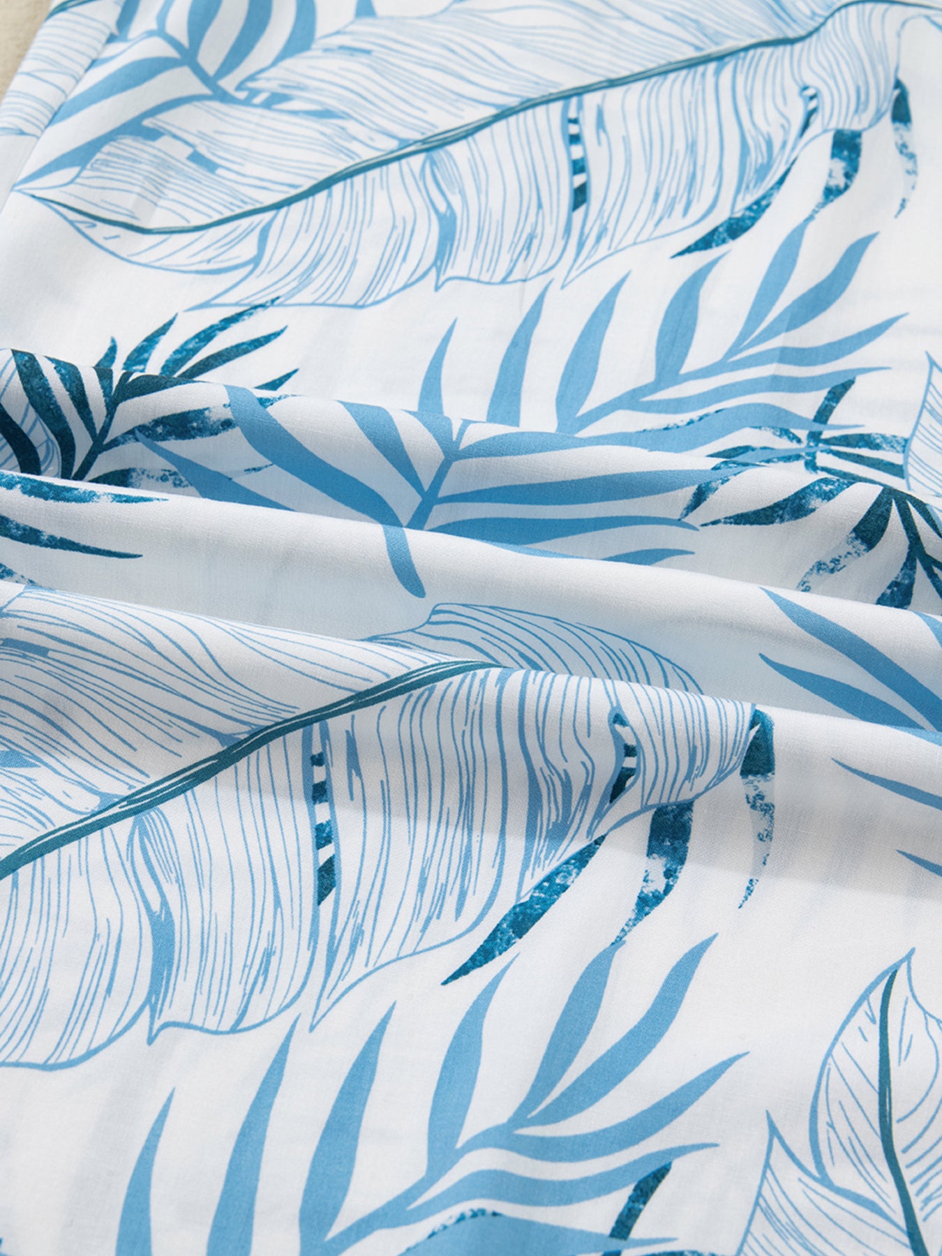 Close-up of blue leaf pattern fabric on a white background