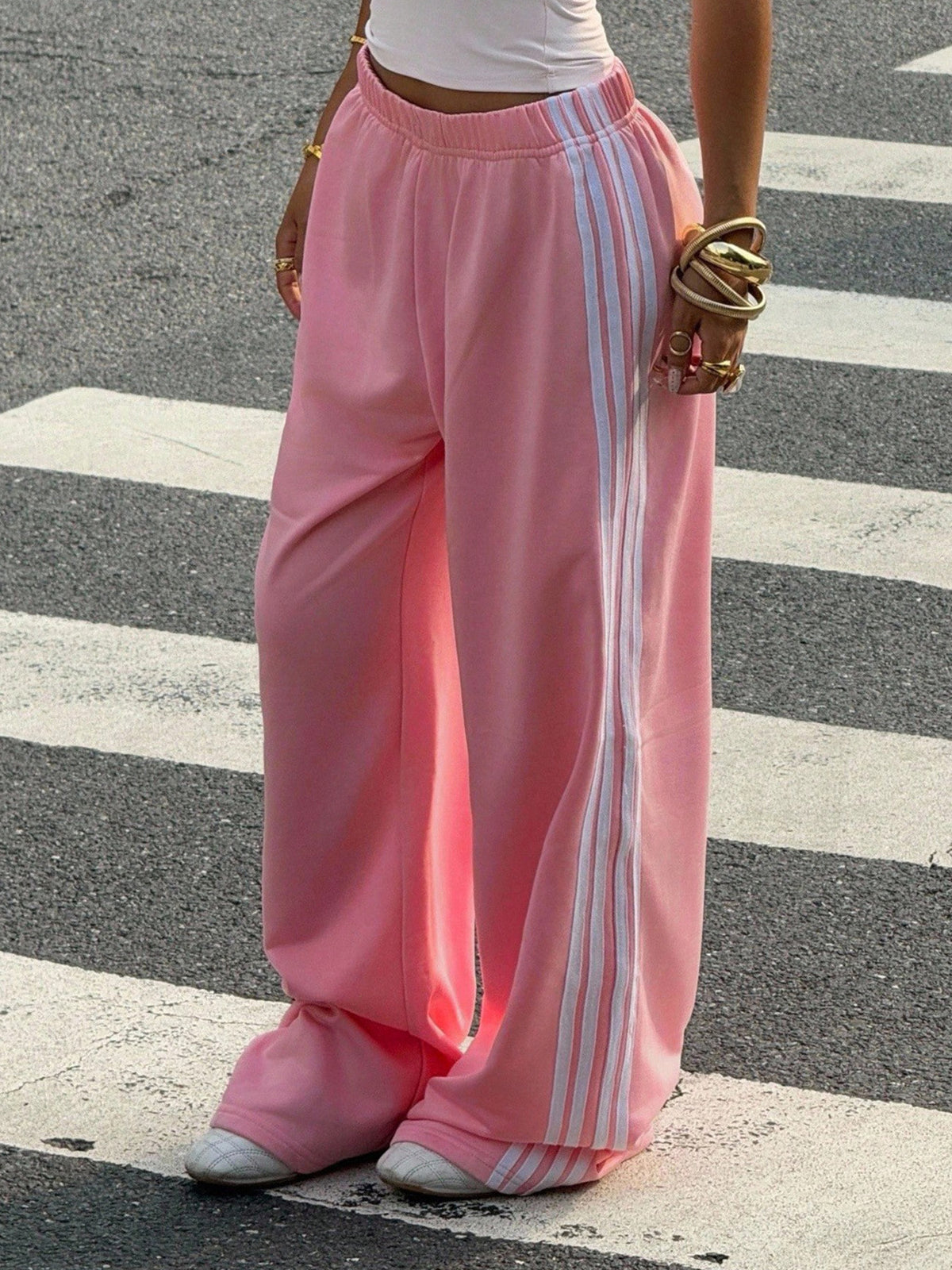 Person wearing pink pants with white stripes on a crosswalk