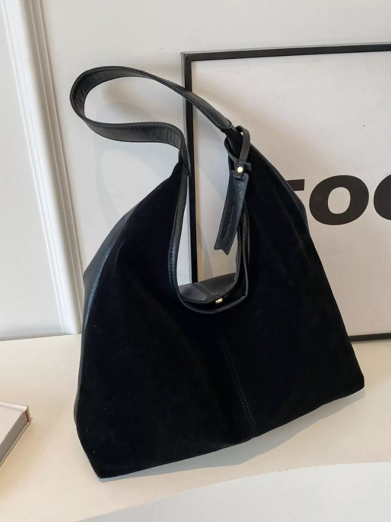 Black handbag on a light surface with a blurred background