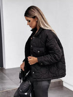 Woman wearing a black quilted jacket in an indoor setting