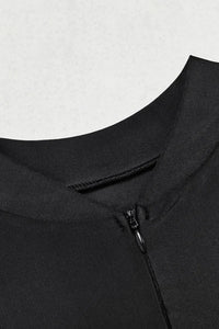 Close-up of a black garment with a zipper on a light gray background