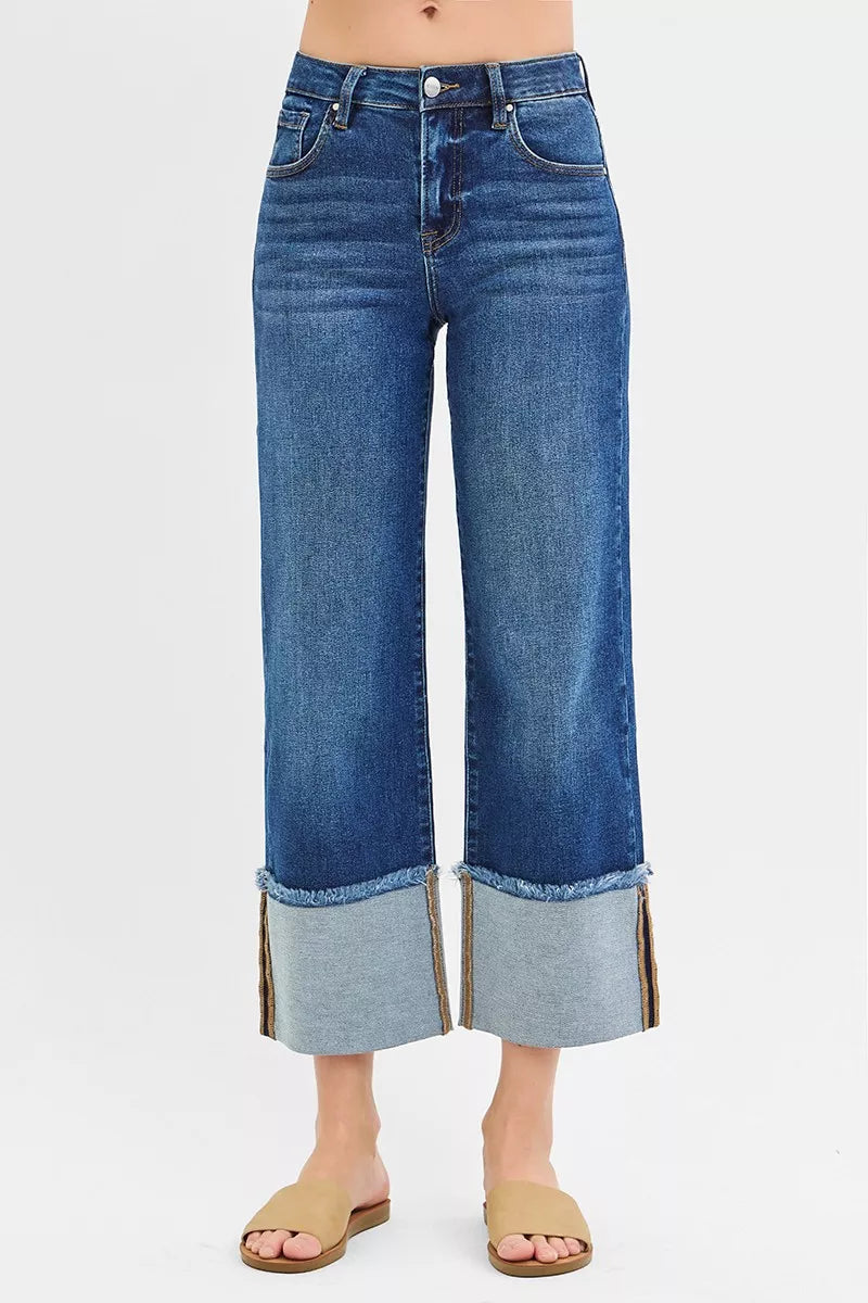 Blue jeans with cuffed hems on a white background