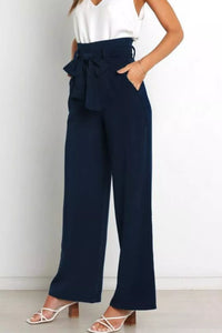 Navy wide-leg pants with a white top on a plain background