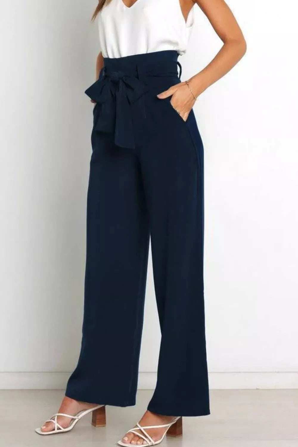 Navy wide-leg pants with a white top on a plain background