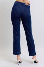 Blue jeans worn by a person on a plain background