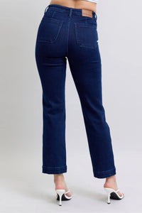 Blue jeans worn by a person on a plain background