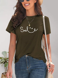 Woman wearing a green t-shirt with 'Smile' text and smiling.