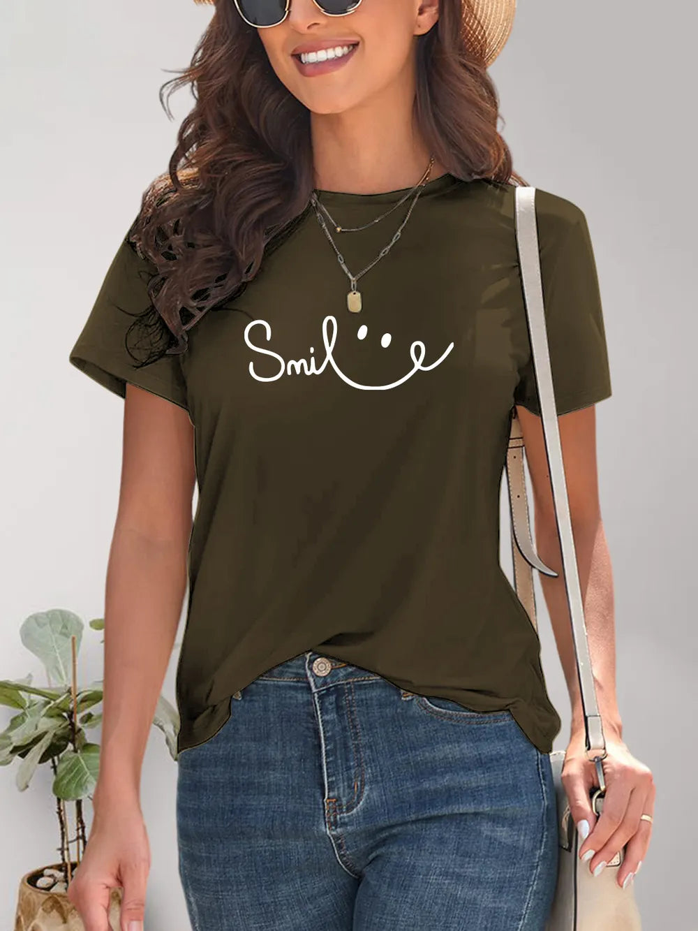 Woman wearing a green t-shirt with 'Smile' text and smiling.