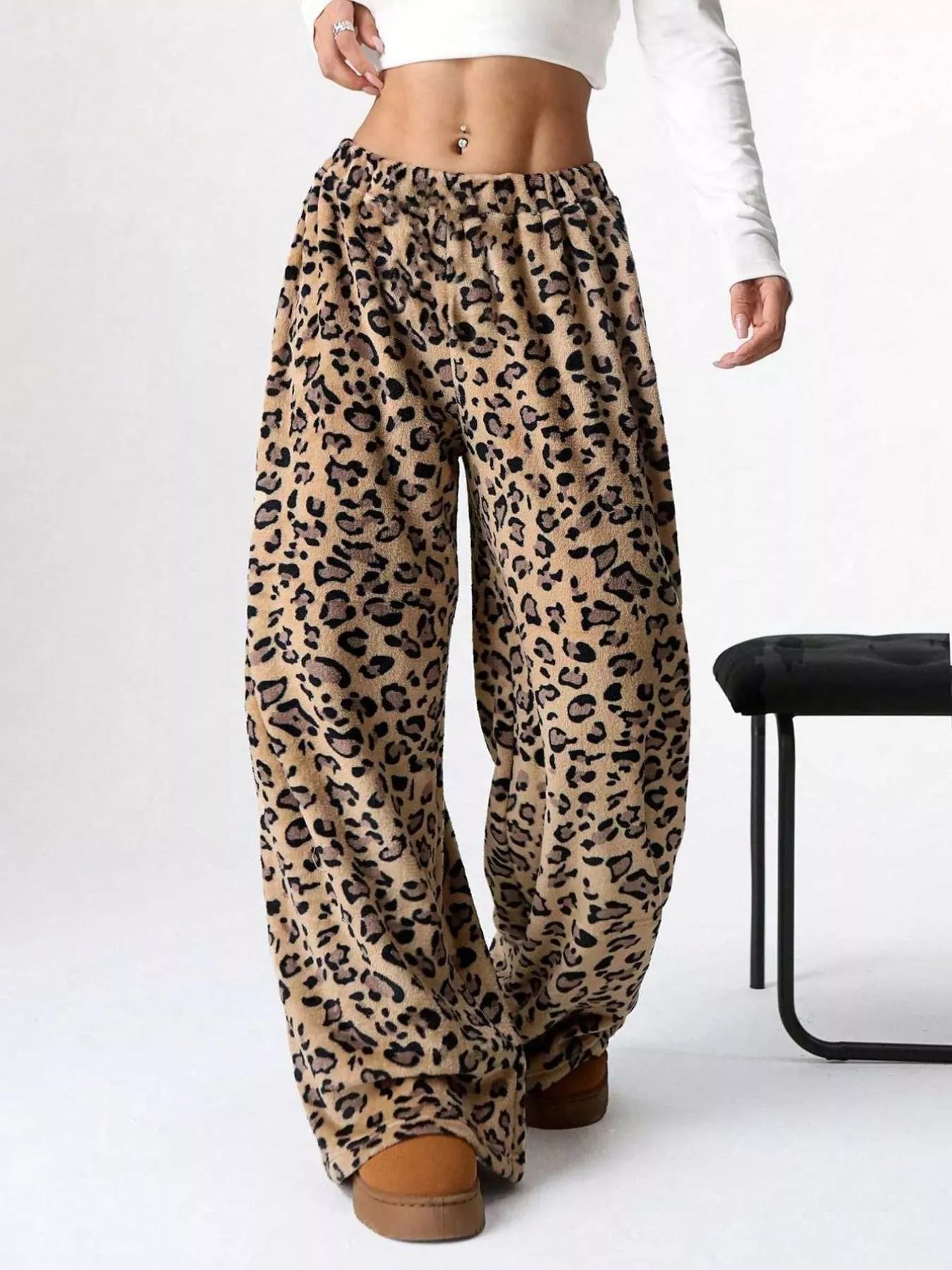 Leopard print pants worn by a person on a white background