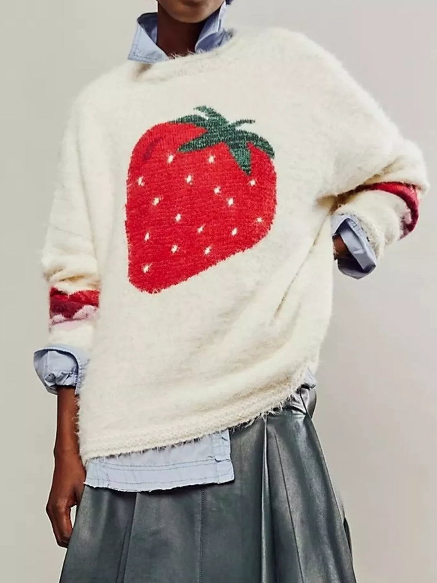 Person wearing a sweater with a strawberry design on a plain background
