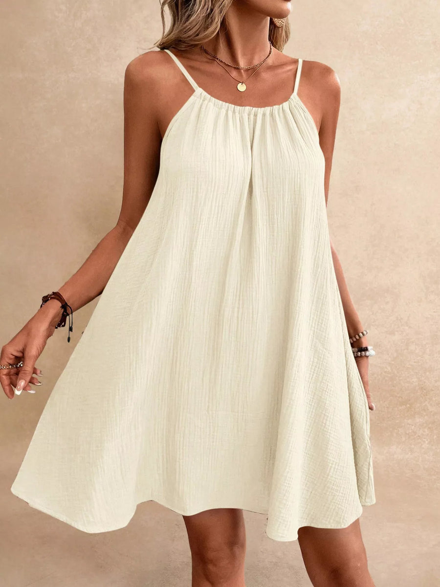 Woman wearing a white dress against a beige background