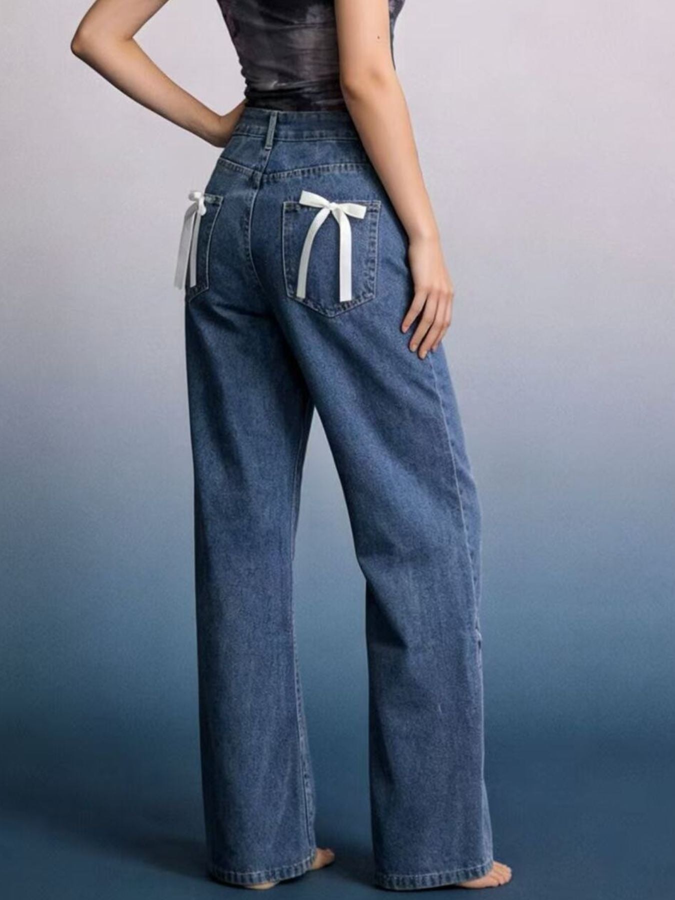 Person wearing wide-leg jeans with a plain background