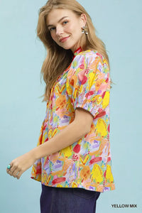 Woman wearing a colorful floral blouse against a light blue background