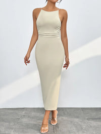 Woman wearing a beige sleeveless dress against a white background
