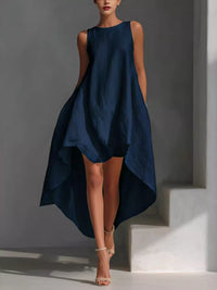 Woman wearing a navy blue dress against a gray background