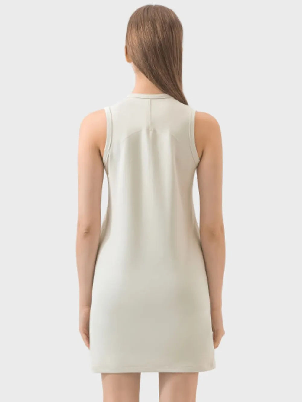 Woman wearing a beige sleeveless dress on a white background