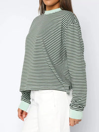 Person wearing a green and white striped sweater on a white background
