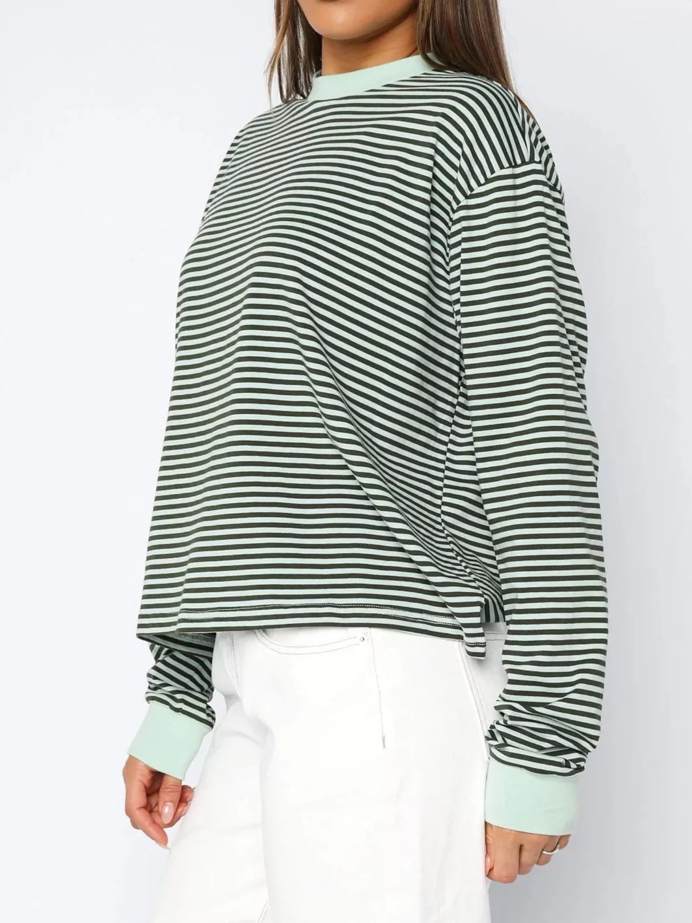 Person wearing a green and white striped sweater on a white background
