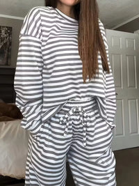 Person wearing a gray and white striped pajama set indoors.