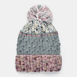 Knitted beanie with a pom-pom on a white background