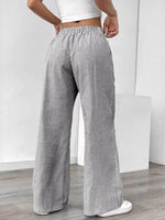Person wearing gray striped wide-leg pants against a white background