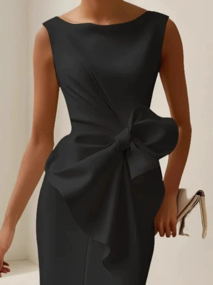 Black dress with a large bow detail on a neutral background