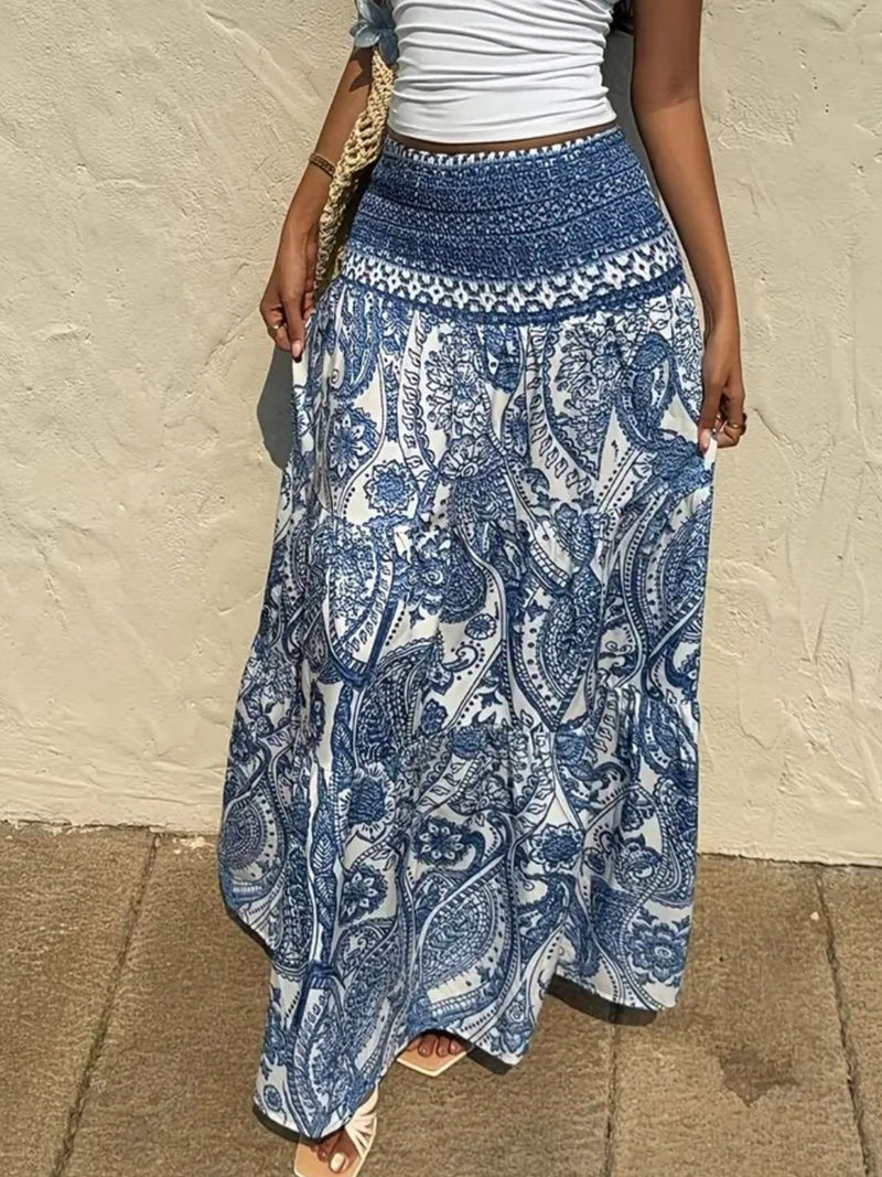 Person wearing a blue and white patterned skirt against a beige wall.